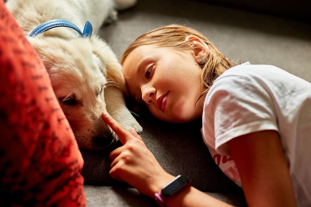 Young girl touching the nose of her emotional support animal.